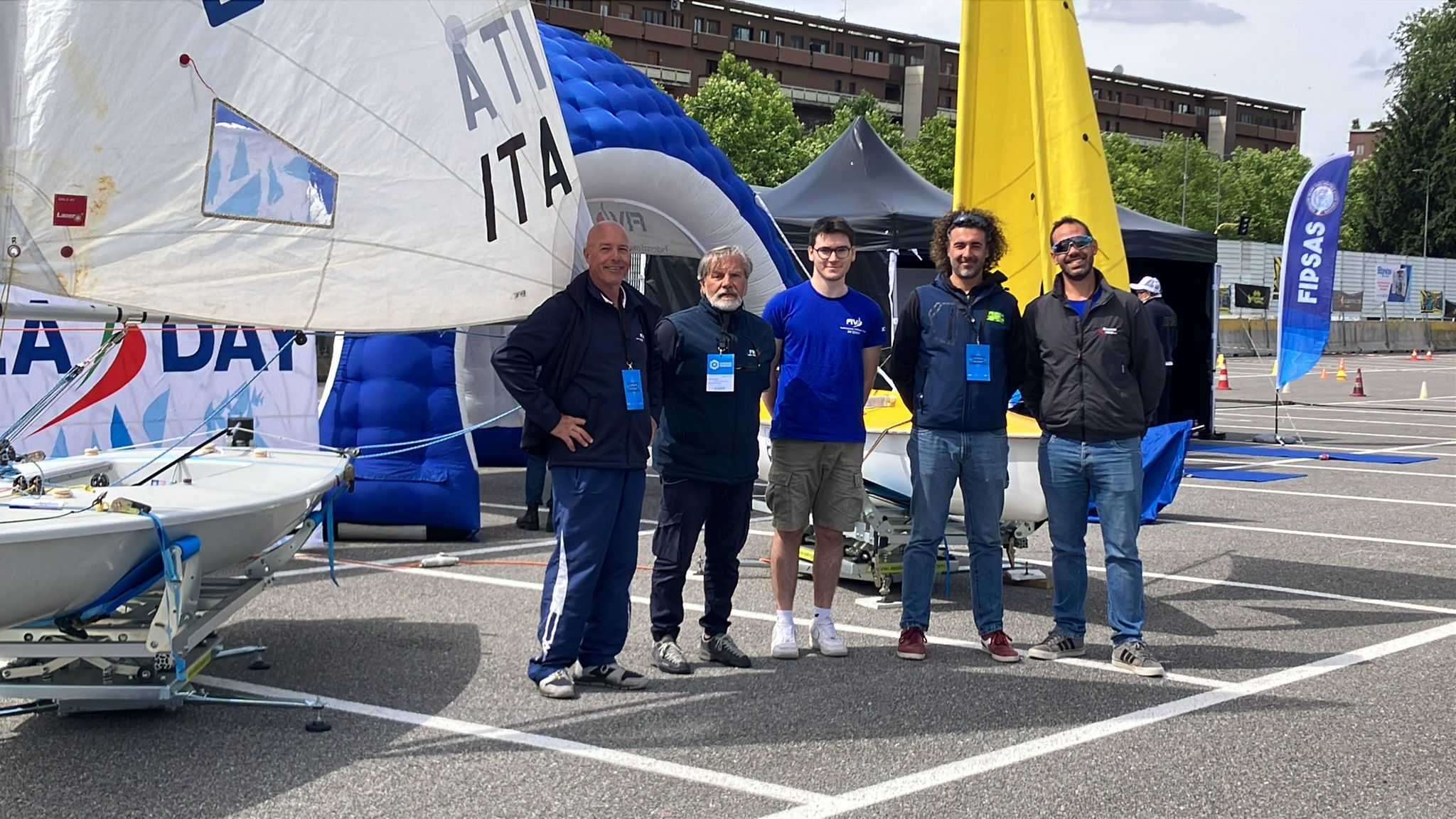 Foto di gruppo dei rappresentanti della XV Zona in mezzo a delle imbarcazioni durante l'evento